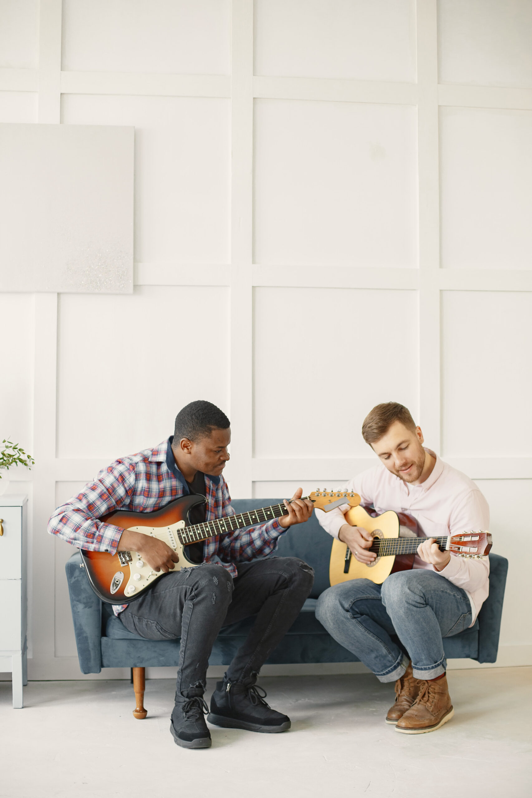 Men play guitar. Writing music. African and caucasian men.
